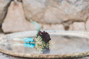 plum teal boutonniere on gold vintage tray