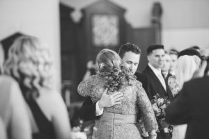 groom hugging mother of the bride black and white